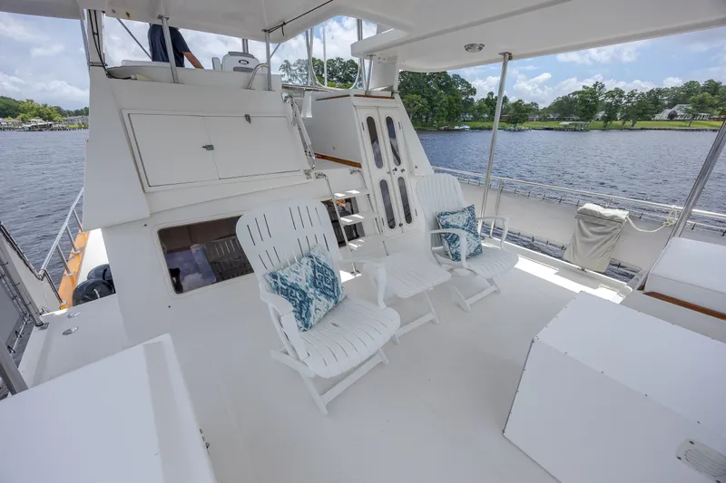  Yacht Photos Pics 1989 Offshore Yachts 48 Yachtfisher deck with chairs, cushions, and scenic water view.