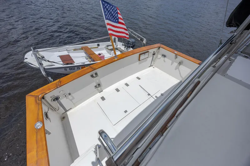  Yacht Photos Pics 1989 Offshore Yachts 48 Yachtfisher deck with American flag, docked on calm water.