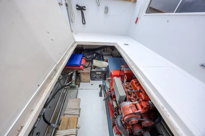  Yacht Photos Pics Engine compartment of 1989 Offshore Yachts 48 Yachtfisher, showcasing mechanical components and storage.