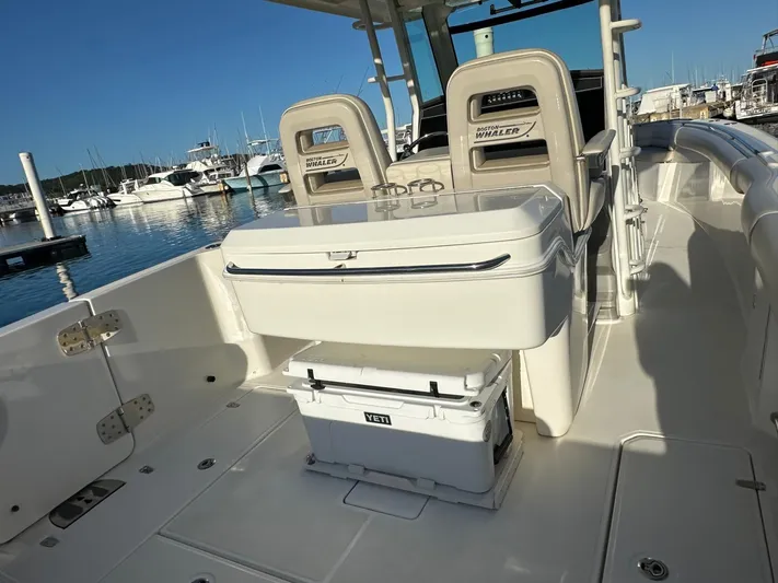  Yacht Photos Pics 2017 Boston Whaler 330 Outrage boat interior with seating and Yeti cooler at marina.