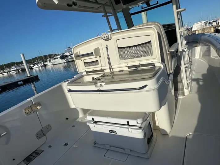  Yacht Photos Pics 2017 Boston Whaler 330 Outrage boat interior with fishing station and cooler.