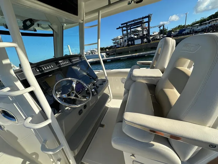  Yacht Photos Pics 2017 Boston Whaler 330 Outrage helm with dual seats and modern controls, dockside view.