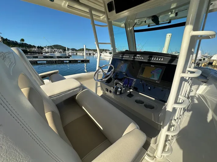  Yacht Photos Pics 2017 Boston Whaler 330 Outrage boat interior with helm, steering wheel, and navigation screens.