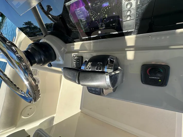  Yacht Photos Pics Control panel of a 2017 Boston Whaler 330 Outrage boat with steering wheel and throttle.