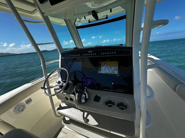  Yacht Photos Pics 2017 Boston Whaler 330 Outrage helm with navigation system, steering wheel, and ocean view.
