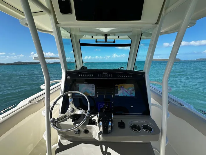  Yacht Photos Pics 2017 Boston Whaler 330 Outrage helm with navigation screens, steering wheel, and ocean view.