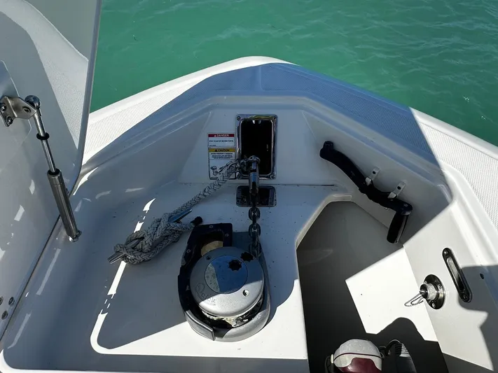  Yacht Photos Pics 2017 Boston Whaler 330 Outrage anchor compartment with winch and rope, on calm water.