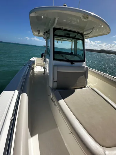  Yacht Photos Pics 2017 Boston Whaler 330 Outrage boat on water, showcasing sleek design and spacious deck.