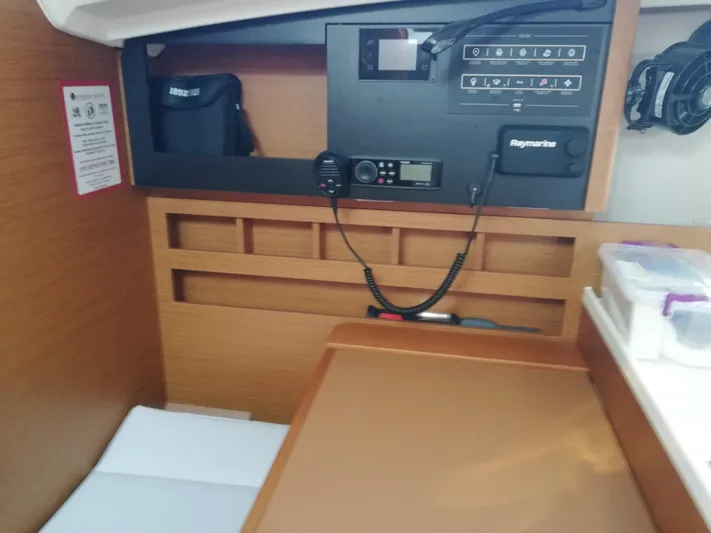  Yacht Photos Pics Navigation station of 2020 Jeanneau Sun Odyssey 410 sailboat with control panel and radio equipment.