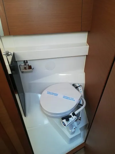  Yacht Photos Pics Compact bathroom in 2020 Jeanneau Sun Odyssey 410 sailboat, featuring modern marine toilet.