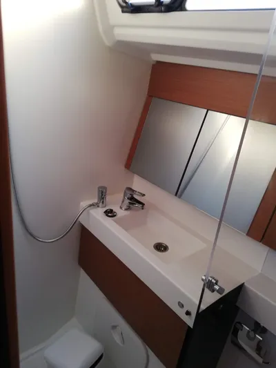  Yacht Photos Pics Bathroom interior of 2020 Jeanneau Sun Odyssey 410 yacht, featuring modern sink and mirror.