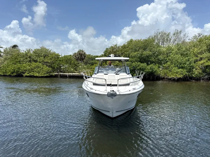  Yacht Photos Pics 2022 Jeanneau Leader 10.5 WA Series 2 boat on calm water, surrounded by lush greenery.