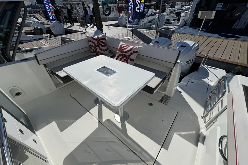  Yacht Photos Pics 2024 Jeanneau Leader 10.5 CC boat interior with seating and table, docked at marina.