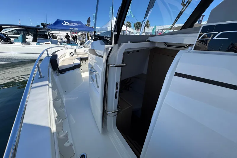  Yacht Photos Pics 2024 Jeanneau Leader 10.5 CC boat interior with open cabin door at a marina.