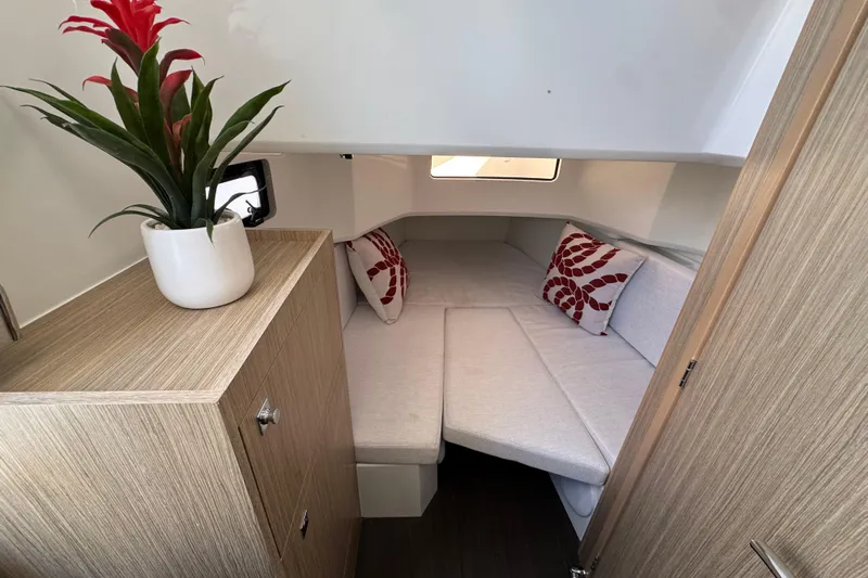  Yacht Photos Pics 2024 Jeanneau Leader 10.5 CC cabin interior with cozy seating and decorative plant.