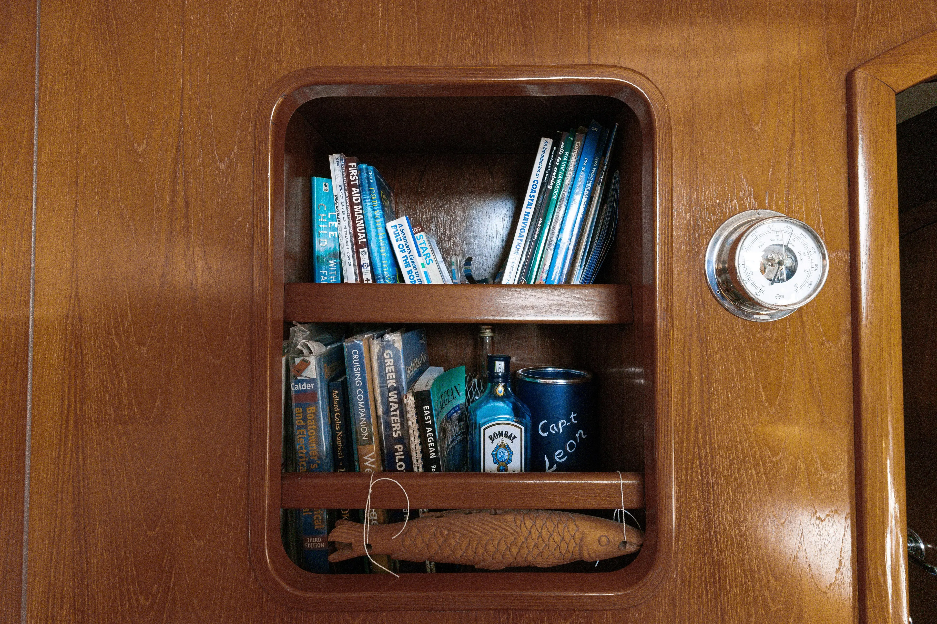  Yacht Photos Pics Wooden shelf with nautical books and items on a 1999 Beneteau Oceanis 44 CC yacht.