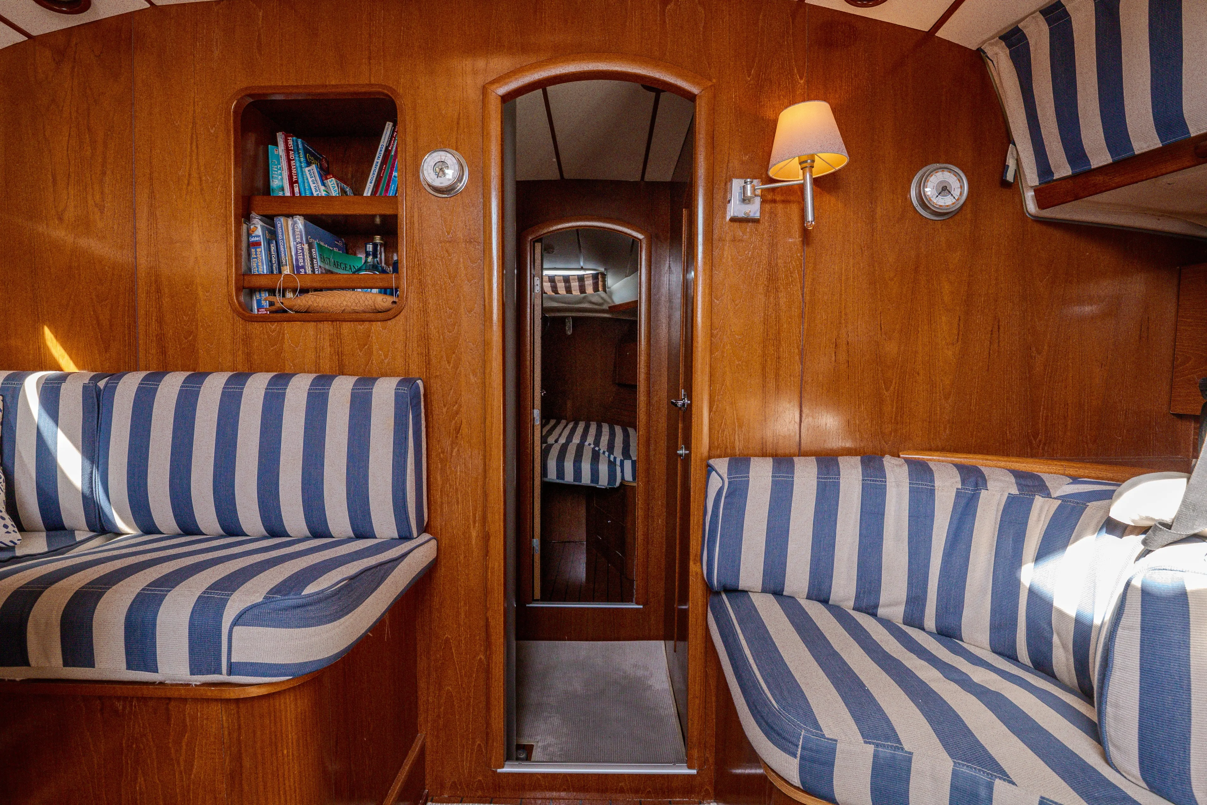  Yacht Photos Pics Interior of 1999 Beneteau Oceanis 44 CC yacht with striped seating and wooden finish.