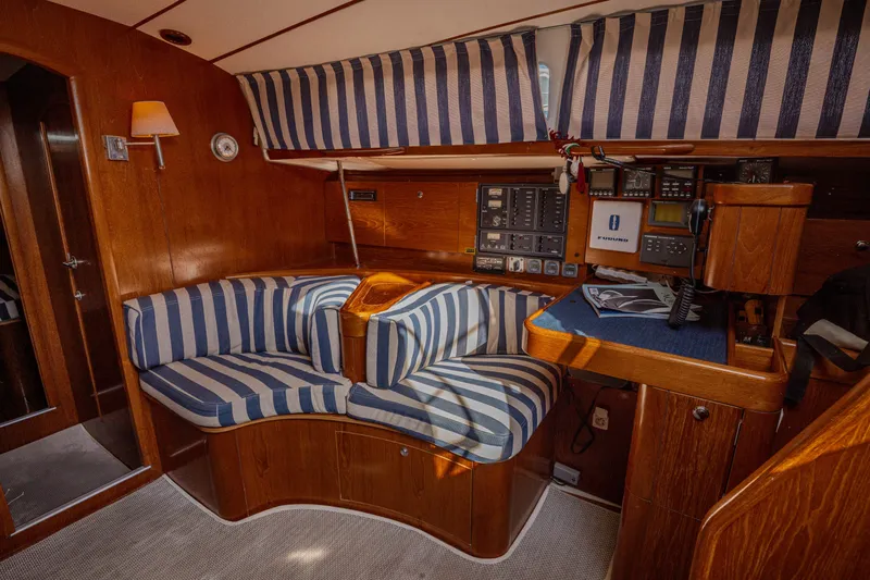  Yacht Photos Pics Interior of 1999 Beneteau Oceanis 44 CC yacht with striped seating and navigation equipment.