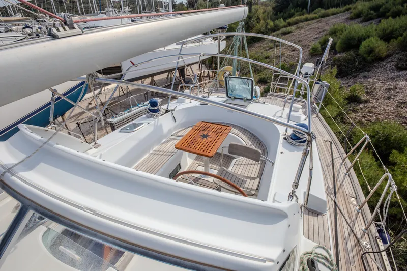  Yacht Photos Pics 1999 Beneteau Oceanis 44 CC sailboat deck with seating and wooden table.