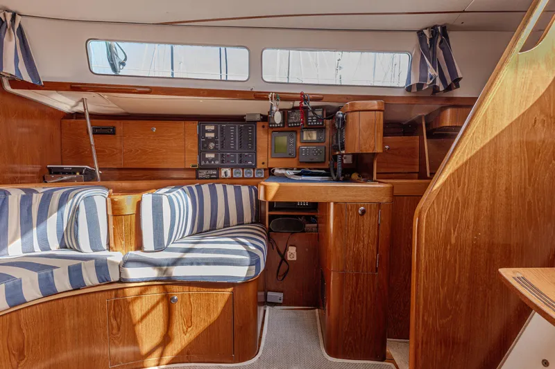  Yacht Photos Pics Interior of 1999 Beneteau Oceanis 44 CC yacht with striped seating and navigation equipment.