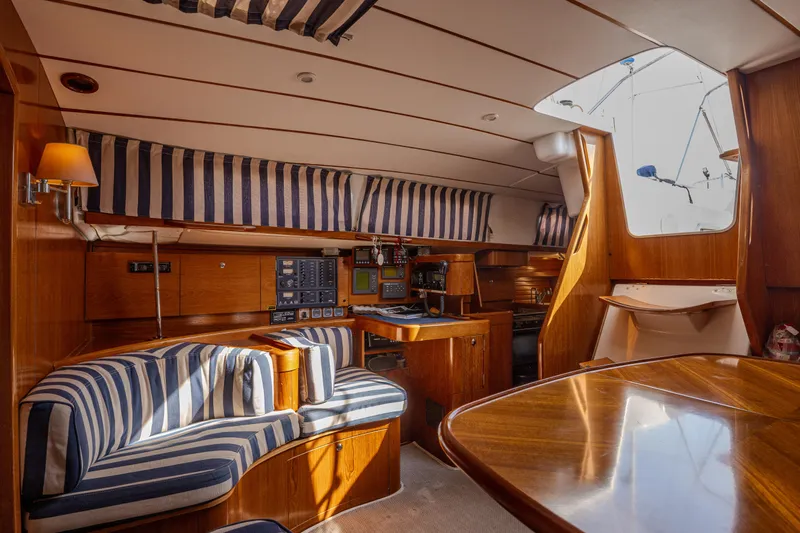  Yacht Photos Pics Interior of 1999 Beneteau Oceanis 44 CC yacht with striped upholstery and wooden finishes.