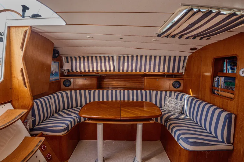  Yacht Photos Pics Interior of 1999 Beneteau Oceanis 44 CC with striped seating and wooden table.
