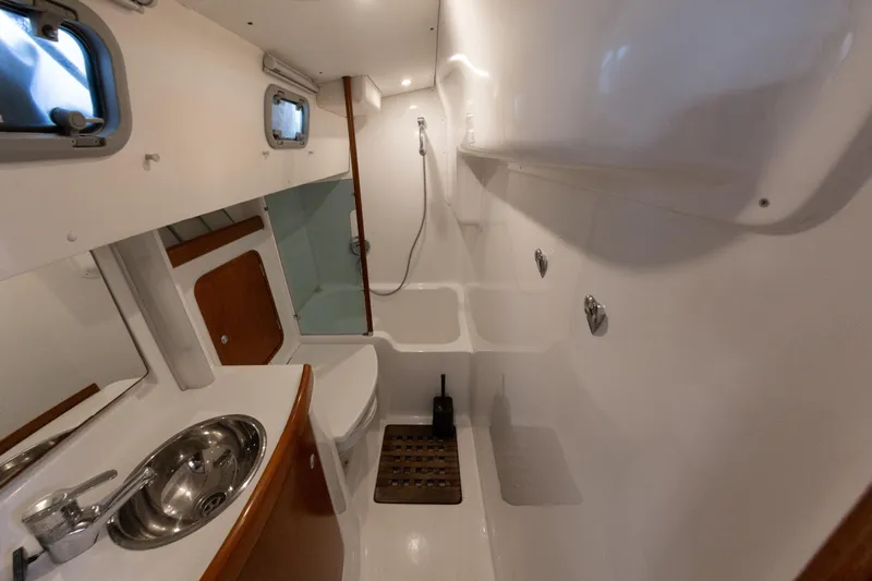  Yacht Photos Pics Bathroom interior of 1999 Beneteau Oceanis 44 CC yacht, featuring sink, toilet, and shower.