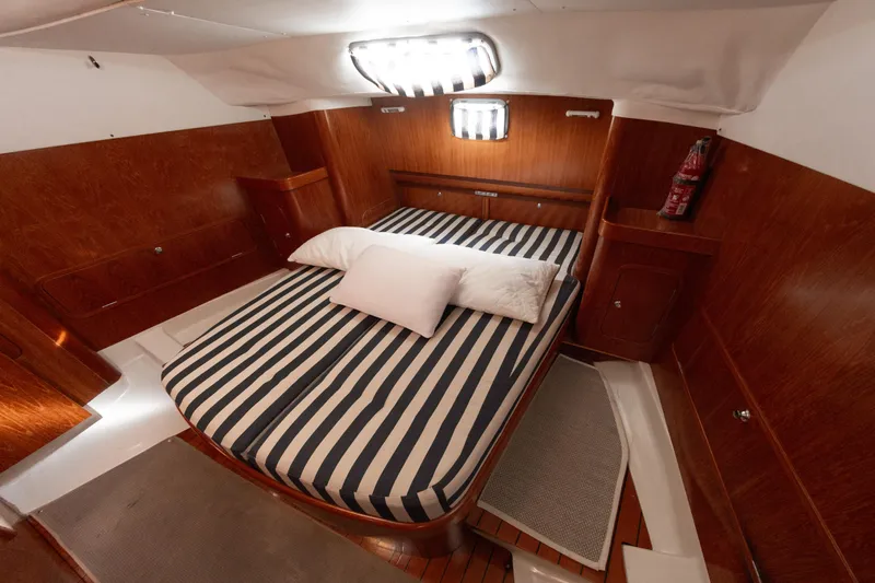  Yacht Photos Pics Luxurious cabin interior of 1999 Beneteau Oceanis 44 CC with striped bedding.