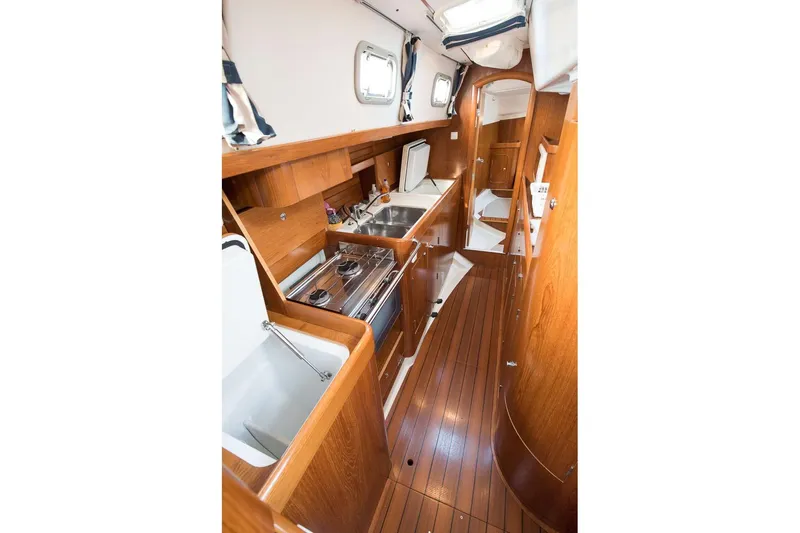  Yacht Photos Pics Interior of 1999 Beneteau Oceanis 44 CC yacht, featuring a sleek wooden galley design.