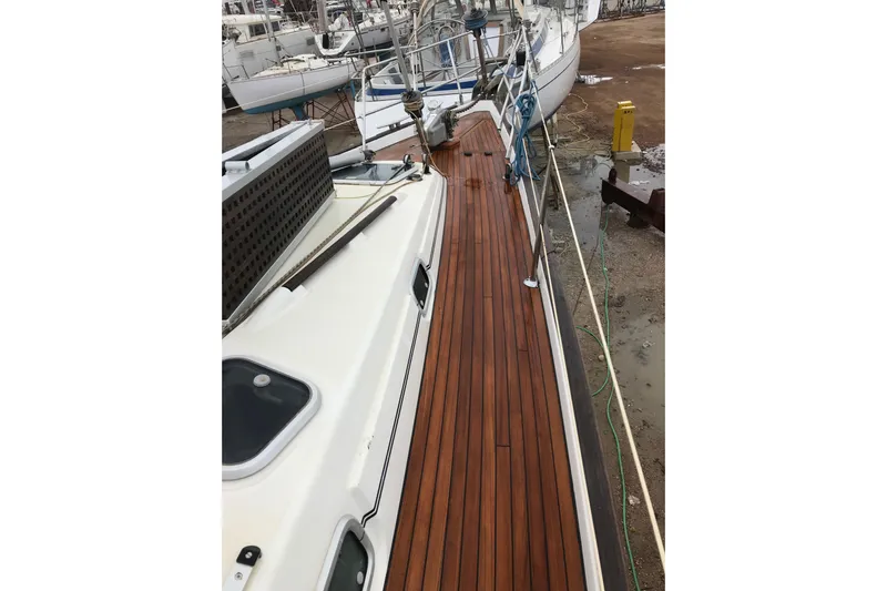  Yacht Photos Pics 1999 Beneteau Oceanis 44 CC sailboat with polished wooden deck in marina.