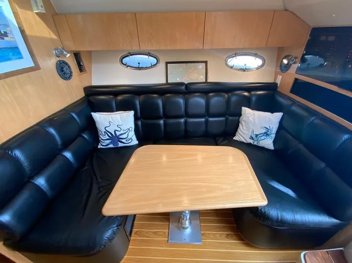 Vixen Yacht Photos Pics Interior of 2002 Tiara Yachts 3500 Open with leather sofa and wooden table.
