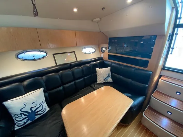 Vixen Yacht Photos Pics Interior of 2002 Tiara Yachts 3500 Open with leather sofa and wooden table.