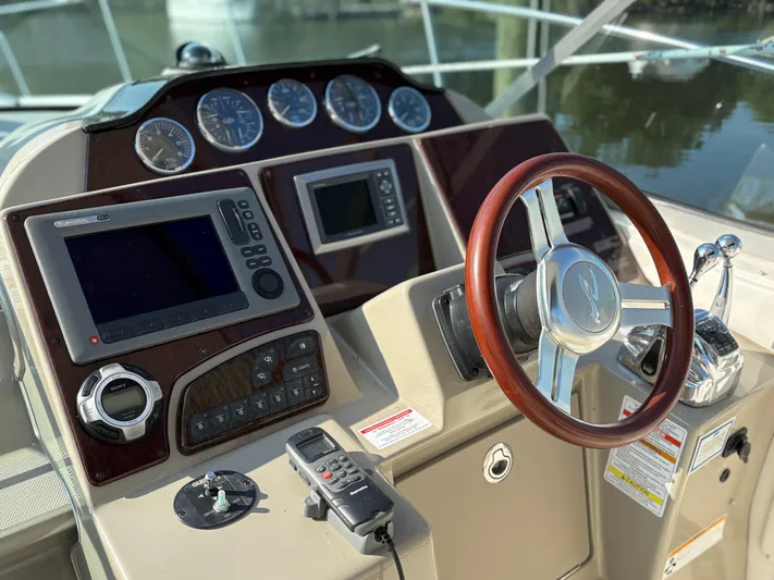  Yacht Photos Pics Helm of 2012 Sea Ray 350 Sundancer with wood steering wheel and navigation controls.
