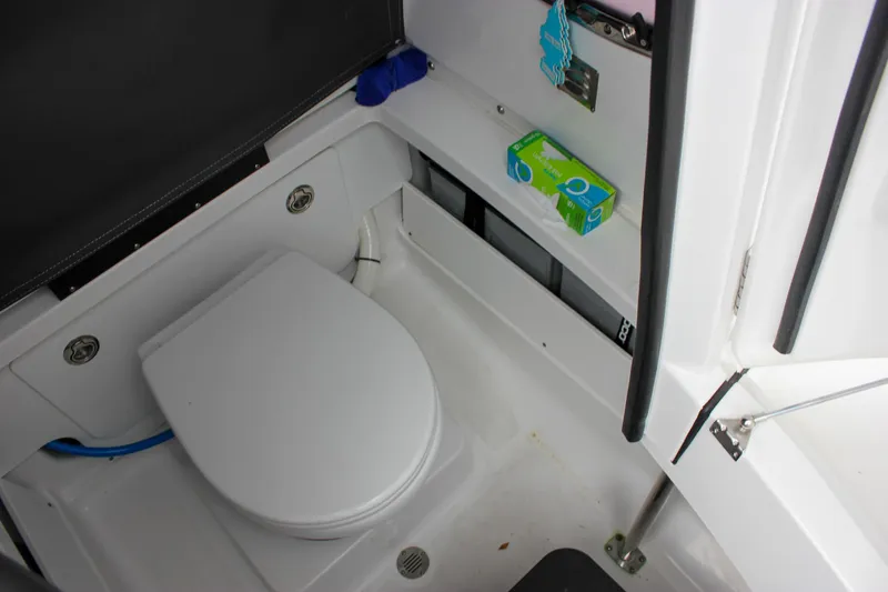 Irish Eyes Yacht Photos Pics 2023 Blackfin 252 CC boat interior with compact marine toilet and storage shelves.
