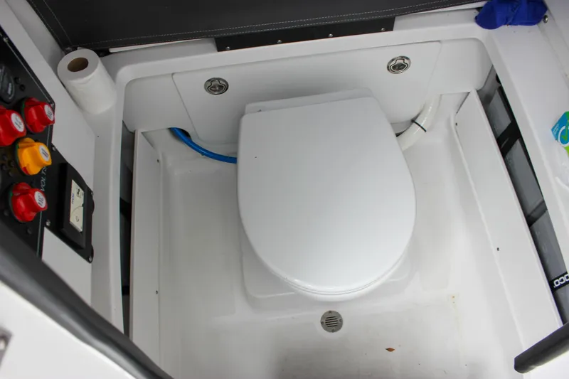 Irish Eyes Yacht Photos Pics 2023 Blackfin 252 CC boat interior with a compact marine toilet setup.