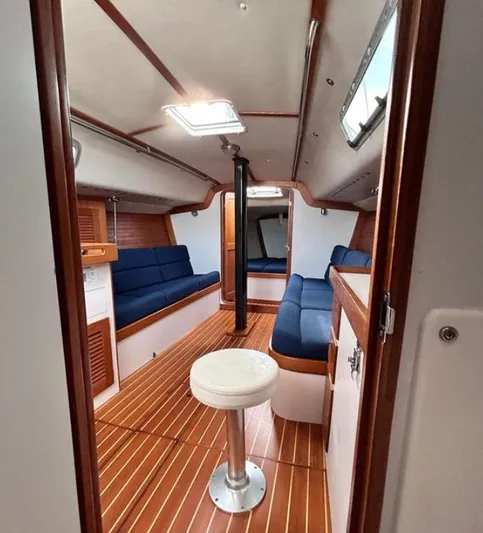 Sundog Yacht Photos Pics Interior of 2006 J Boats J/124 sailboat with wooden flooring and blue seating.