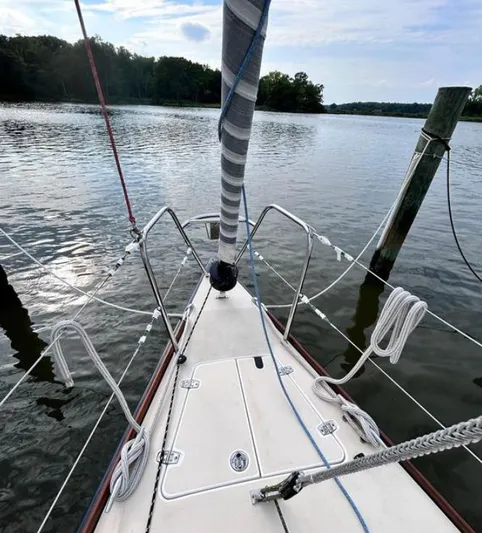 Sundog Yacht Photos Pics Bow of 2006 J Boats J/124 sailboat docked on calm water.