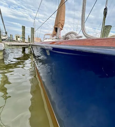 Sundog Yacht Photos Pics 2006 J Boats J/124 sailboat docked, reflecting on calm water under a cloudy sky.