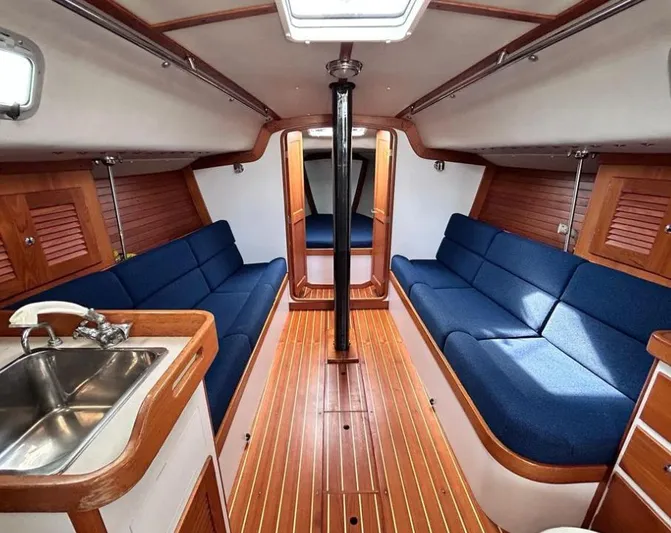 Sundog Yacht Photos Pics Interior of 2006 J Boats J/124 sailboat with blue seating and wooden finishes.
