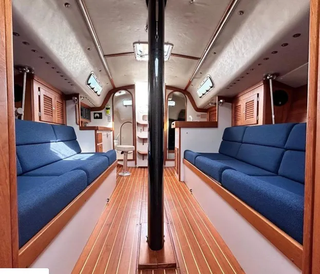 Sundog Yacht Photos Pics Interior of 2006 J Boats J/124 sailboat with blue seating and wooden flooring.