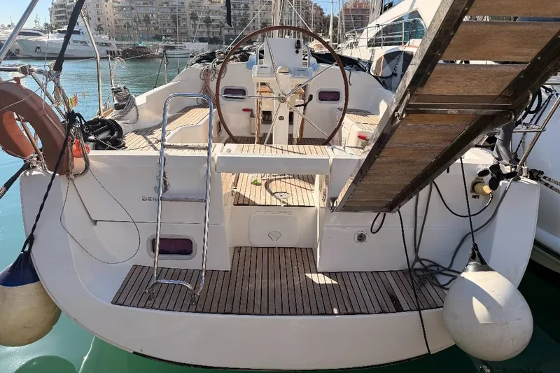  Yacht Photos Pics 2013 Beneteau Oceanis 370 sailboat with wooden deck and steering wheel in marina.