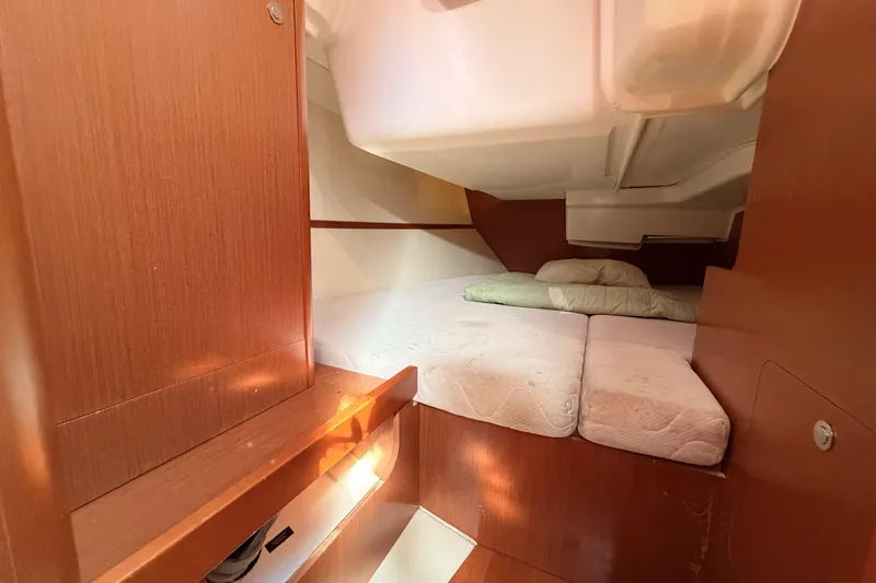  Yacht Photos Pics Cozy cabin interior of 2013 Beneteau Oceanis 370 sailboat with wooden finish and bedding.
