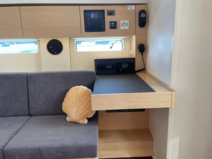 In Stock Yacht Photos Pics 2024 Hanse 410 yacht interior with sofa, shell pillow, and control panel.