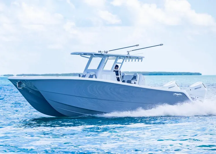  Yacht Photos Pics 2026 Invincible 33 Catamaran cruising on open water under a clear sky.