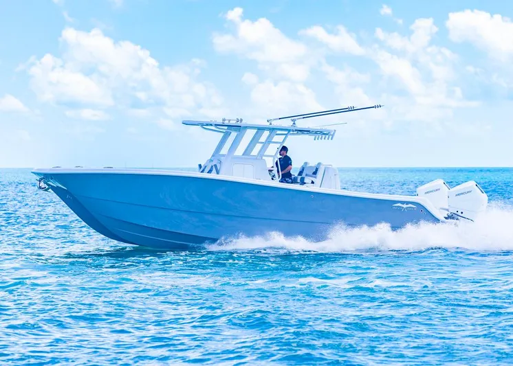  Yacht Photos Pics 2026 Invincible 33 Catamaran cruising on open water under a clear blue sky.