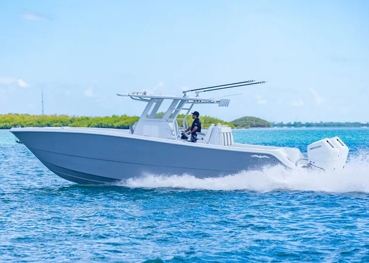  Yacht Photos Pics 2026 Invincible 33 Catamaran cruising on blue water, showcasing sleek design and powerful engines.