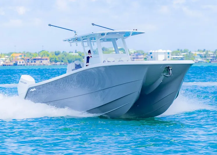  Yacht Photos Pics 2026 Invincible 33 Catamaran cruising on blue ocean waters.