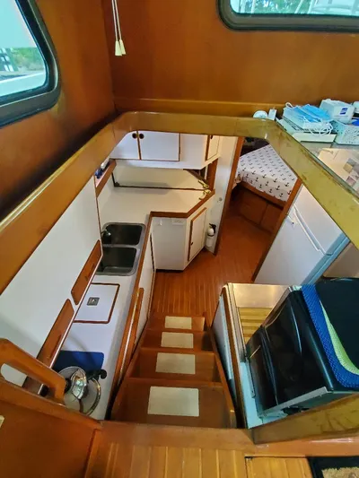 Southern Cross Yacht Photos Pics Interior of 1987 Tayana 45 Expedition Trawler with wooden cabinetry and compact kitchen area.