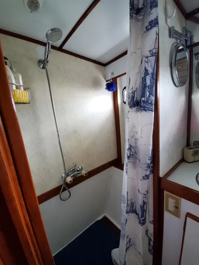 Southern Cross Yacht Photos Pics 1987 Tayana 45 Expedition Trawler bathroom with shower, nautical-themed curtain, and wooden accents.