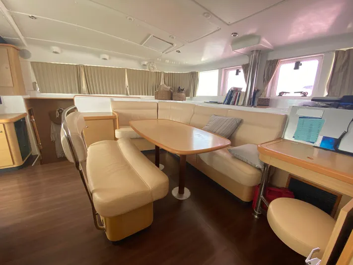  Yacht Photos Pics Interior of 2009 Lagoon 440 catamaran with beige seating, wooden table, and ample natural light.